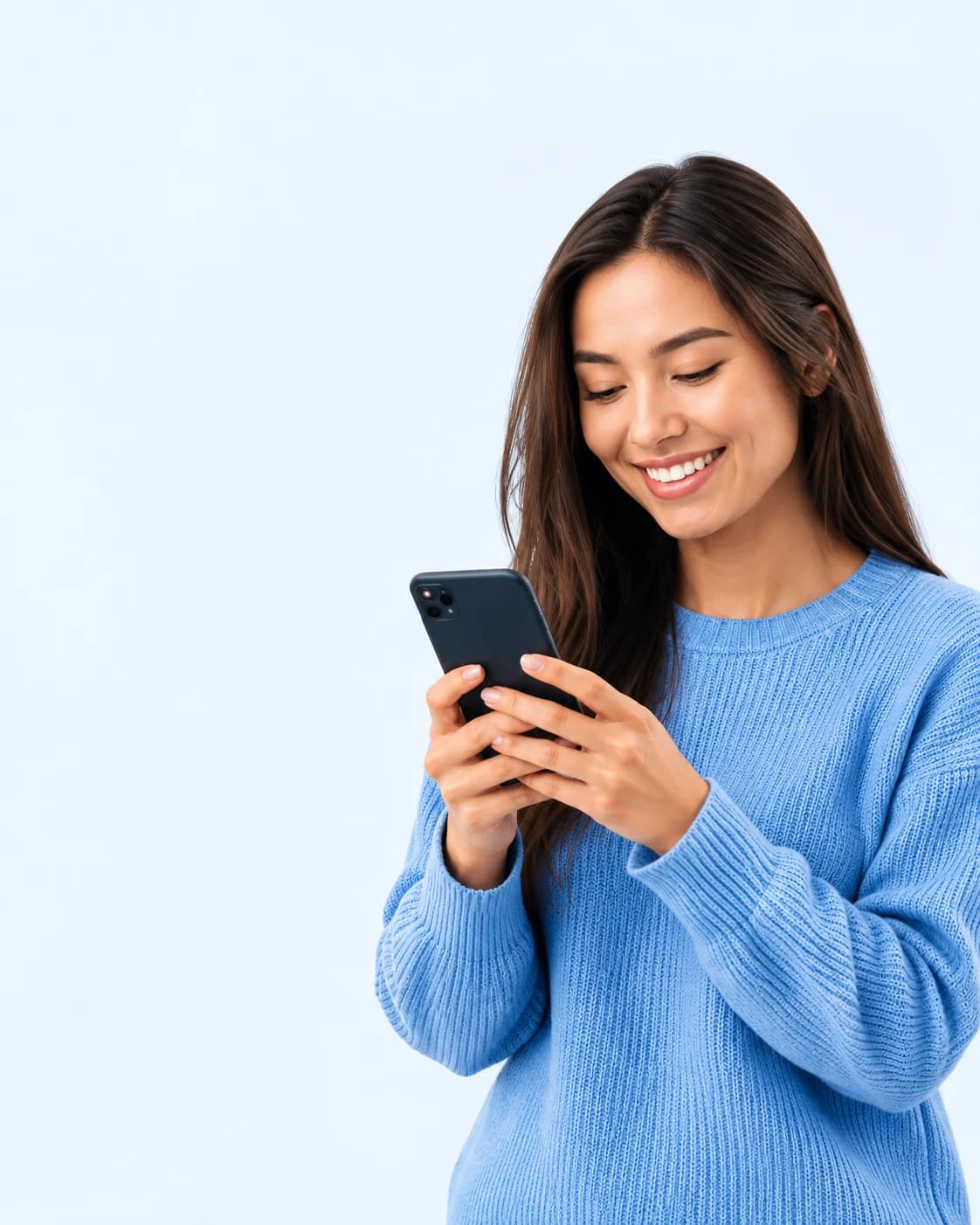 Smiling woman in a blue sweater looking at her phone